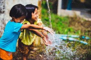 Children smiling at a water well