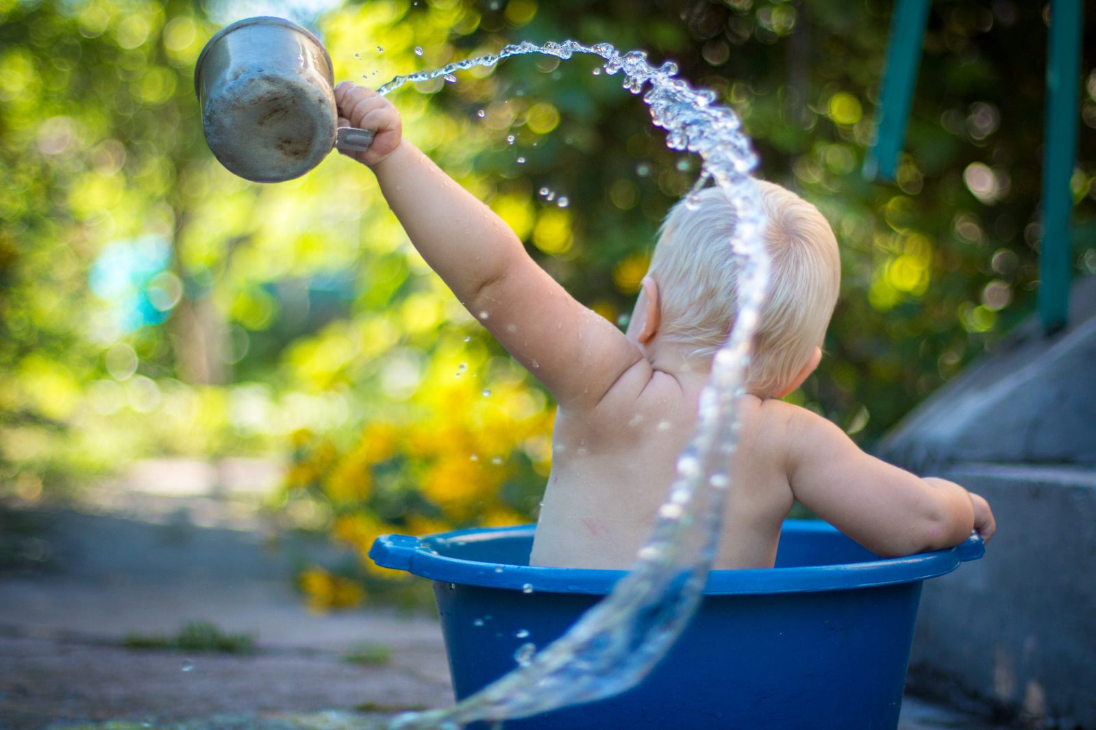 A child bathed in a blue basin of water