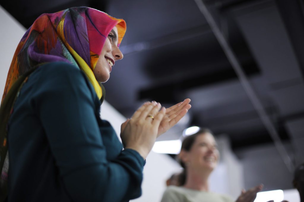 A woman in a hijab clapping