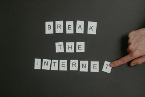 Textual phrase Break the Internet arranged on a black background with a pointing hand.
