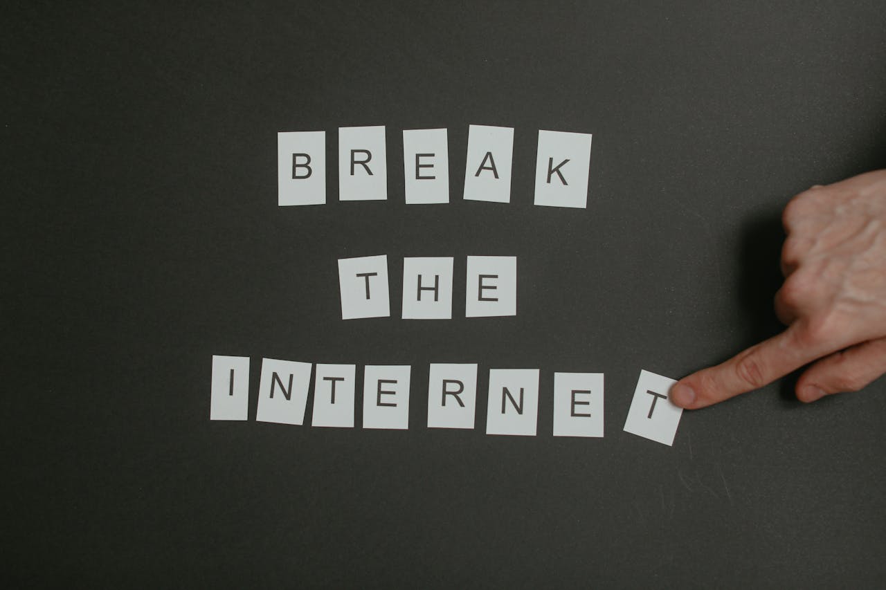 Textual phrase Break the Internet arranged on a black background with a pointing hand.