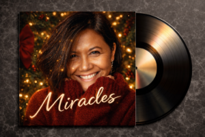 Miracles album cover; a picture of Sheryle Gillihan in a holiday scene wearing a red sweater.